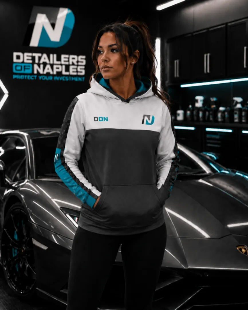 Woman wearing a custom hoodie in front of a sports car